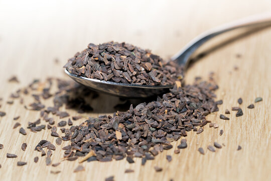wild rue seeds, Peganum harmala in the spoon on a wooden table