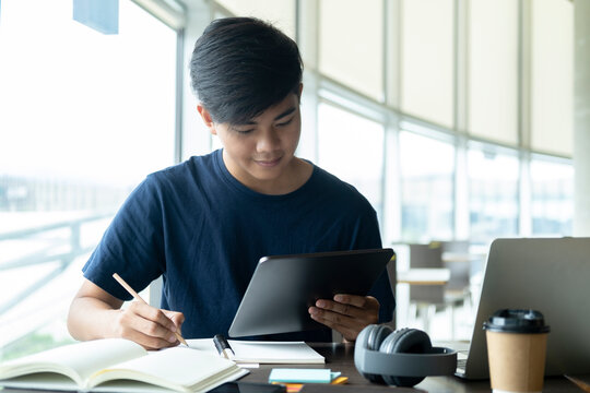 Young collage student using computer and mobile device studying