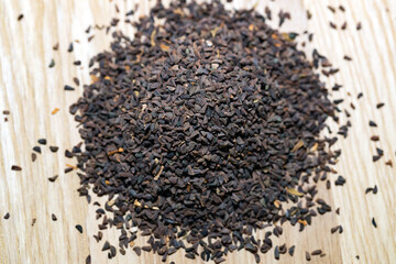 wild rue seeds on a wooden cutting board