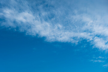 Clear blue sky with few white clouds in a zig zag pattern