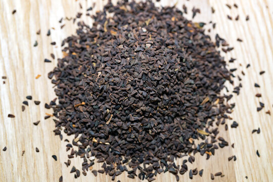 wild rue seeds on a wooden cutting board