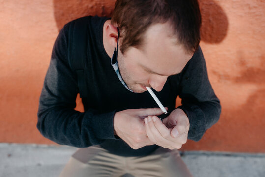 man lighting a cigarette in the street