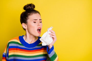 Photo of sick cold brown bun haired girl sneeze hold napkin closed eyes isolated on shine bright...