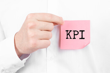 Man attaches a red sticker with text KPI overlay to his white shirt