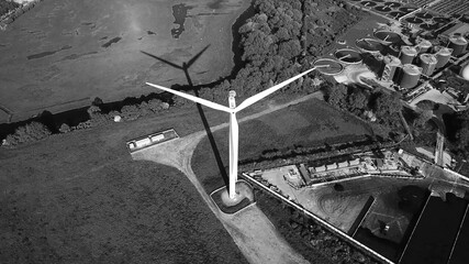 Wind turbine against Industrial district, clean energy production, aerial view black and white - 392078718