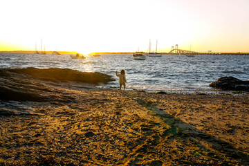 Little girl plays in scenic harbor.
