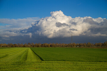 Weather front approaching over dull, modern, flat production landscape 