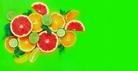 assortment of citrus fruits, on a green background, top view, no people, horizontal
