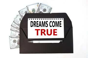 dreams come true, text on white paper on a black envelope. business concept