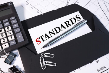 STANDARDS, text on white paper on a black envelope. business concept