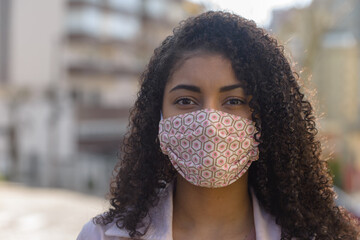 Black woman with facemask on urban background