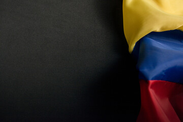 Fototapeta na wymiar flag of ecuador, venezuela, colombia wrinkled on a black background on the right side