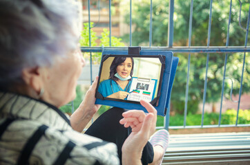 Telemedicine doctor explains to an elderly patient that measurement of bone mineral density is the...
