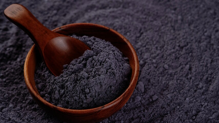 blue butterfly pea powder in wooden bowl close up. superfoods