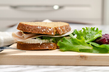 Turkey sandwich with fresh cheese and lettuce. Healthy snack.