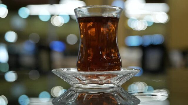 turkish transparent glass of black tea on the bokeh background