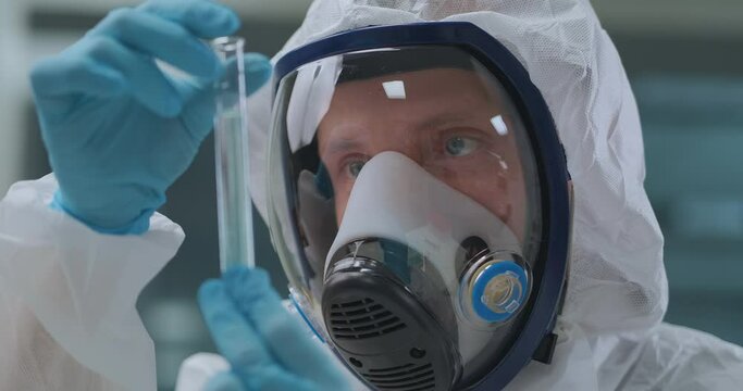virologist is holding in hands tube with vaccine from covid-19, closeup of human face in laboratory
