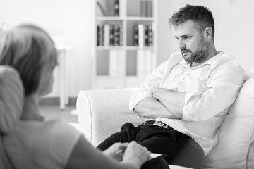 Obraz premium Handsome man with post traumatic stress during psychotherapy
