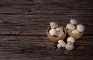champignon mushrooms on a wooden background. fresh mushrooms.