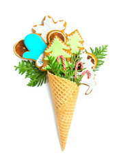 Gingerbread cookies in a waffle cone on a white isolated background. Thuja twigs and snowflakes. Сoncept - delicious original Christmas present.