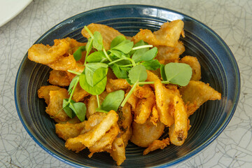 Curly tail fries served with baby spinach on top in Australia