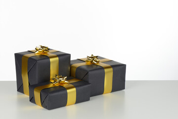 Cajas de regalo de color negro con lazo dorado sobre fondo blanco