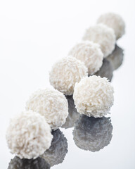 white chocolate truffles on white surface with reflection, selective focus