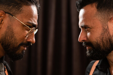 a white man and a black man come face to face with a black backdrop, theater.