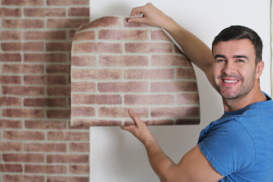 Man attaching brick wall style paper 