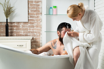 Couple in bath grooming. Skincare in home bathroom. Man and sensual woman. Skin care. Muscular man in bath. Everyday life. Showering person at home lifestyle.