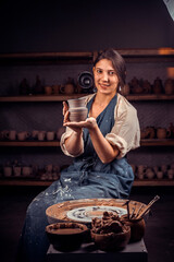 Handicraftsman demonstrates the finished clay product in workshop. Handicraft production.