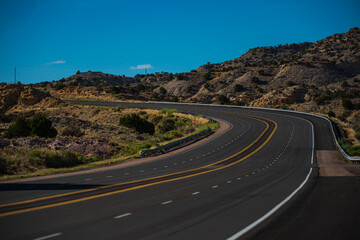Asphalt highway and hill landscape under the blue sky. Road in America.
