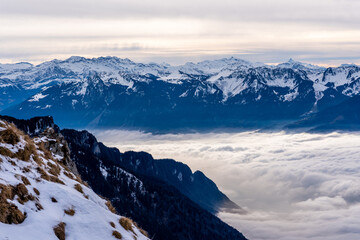 Alpine landscape with peaks covered by snow and clouds. Rochers de Naye, Switzerland.