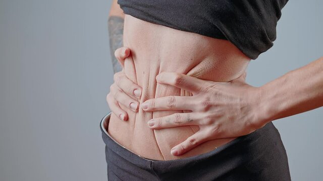 Anorexic young woman squeezing the waist