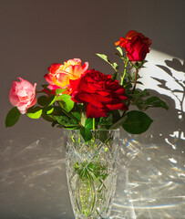 Roses in crystal vase with light reflections.