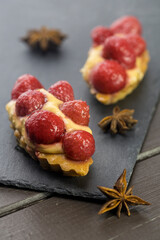 Raspberry cake with cream on a stone plate