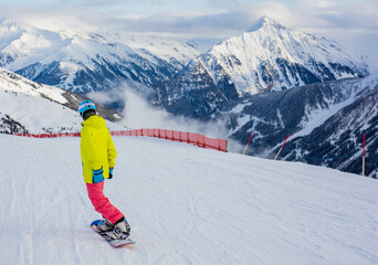 Fototapeta na wymiar Girl snowboarder having fun in the winter ski resort.