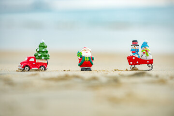 Santa and snowman decoration at ocean beach. Christmas and New Years vacation in hot countries.