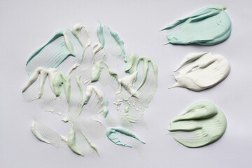 Smears of paste green, blue and white on a white background. The concept of freshness, oral hygiene, teeth cleaning
