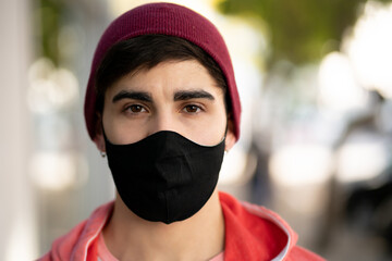 Young man wearing face mask outdoors.