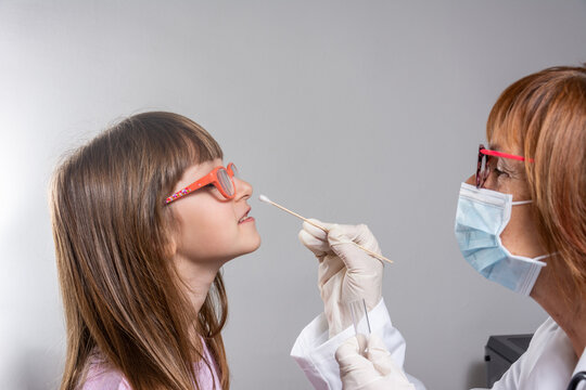 Coronavirus test - Medical worker taking a swab for corona virus sample from potentially infected small girl.