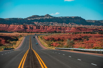 Landscape with rocks, sunny sky with clouds and beautiful asphalt road in the evening in summer.