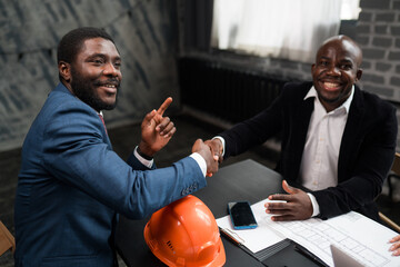 Two African Americans signed a cooperation agreement. Business investors shake hands. Orange...