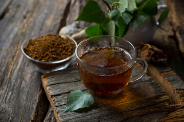 chaga birch mushroom brewed in a cup and in granules. Birch mushroom drink. phytotherapy. Organic superfood. Dry and fresh mushroom trend