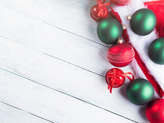 Christmas red and green decor with presents and santa claus cap on white wooden table. Seasonal festive greeting card