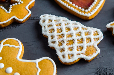 Christmas gingerbread cookies with white icing sugar, on a dark background.