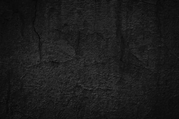 Abstract black background with old cracked concrete wall texture. Dark mysterious stone wallpaper...