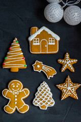 Christmas gingerbread cookies with white icing sugar, on a dark background with a garland.