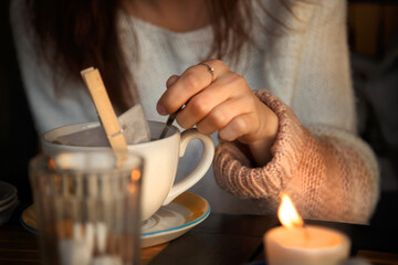 Woman stirring sugar in cup of tea. Autumn mood. Cozy autumn composition. Hygge concept. Soft focus