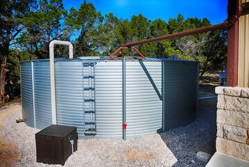 Large rain water tank, ecology friendly, in front of metallic building.